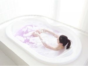 泡のお風呂で身体を洗う女性